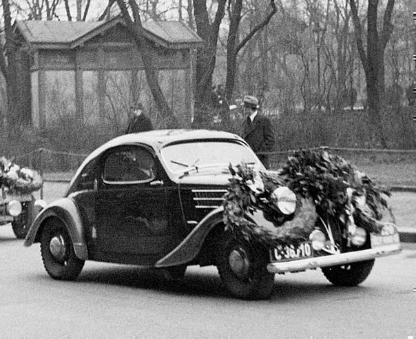 A Skoda Rapid on its return from the 1937 Rally Monte Carlo in front of the Automobile Club headquarters in Prague. 